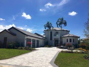 a home with three car garage and to palm trees in the front