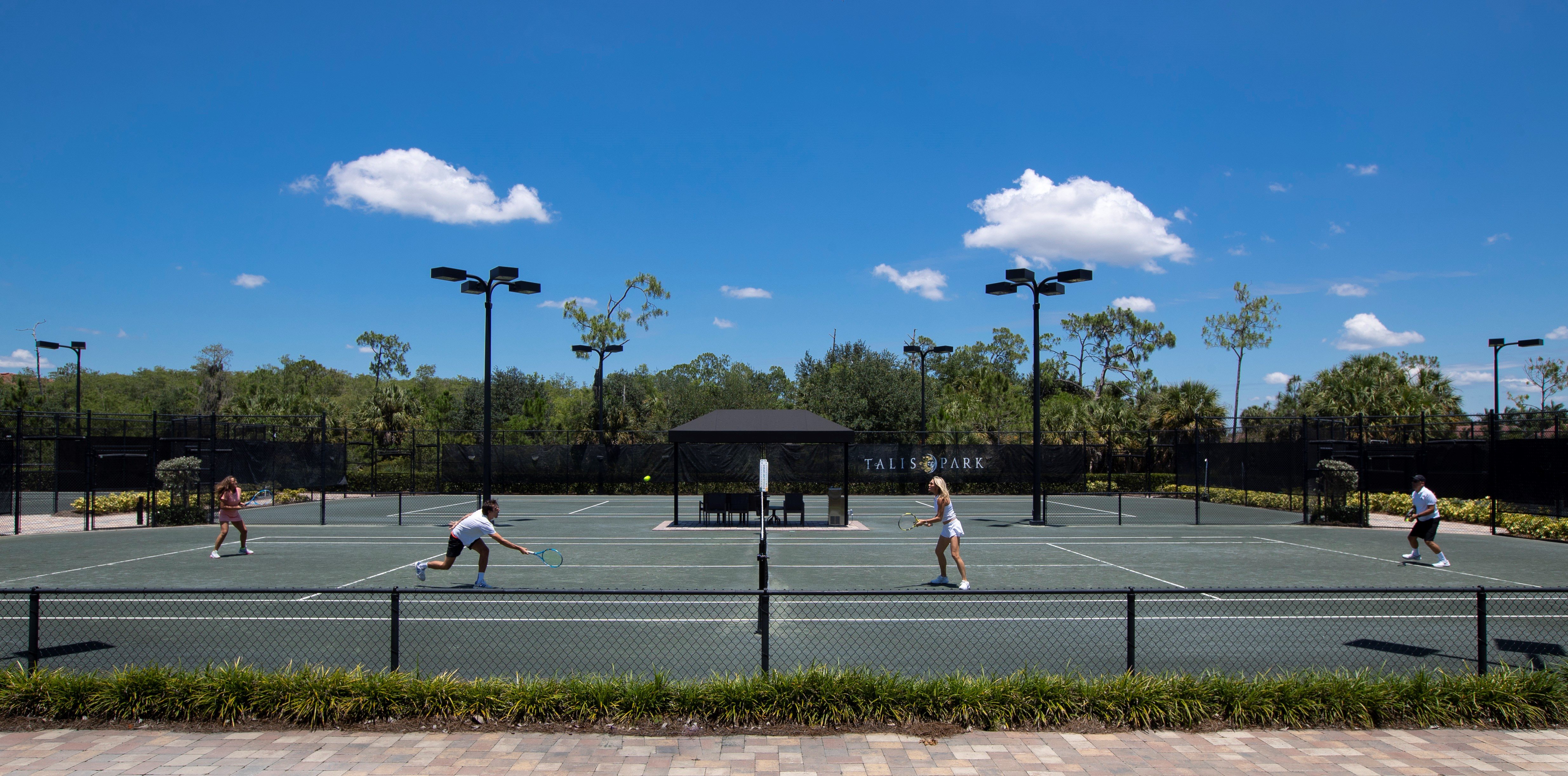 two couples playing tennis in a tennis court